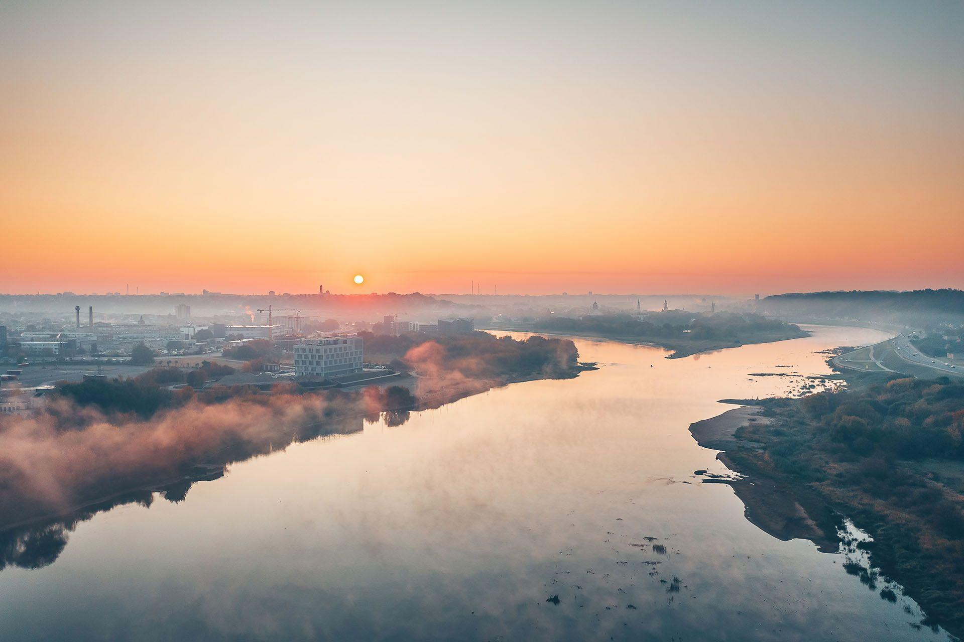 a river running through a valley at sunset